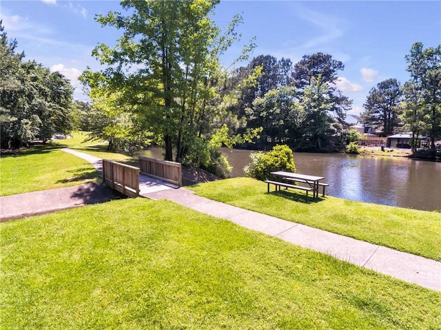 view of home's community featuring a lawn and a water view