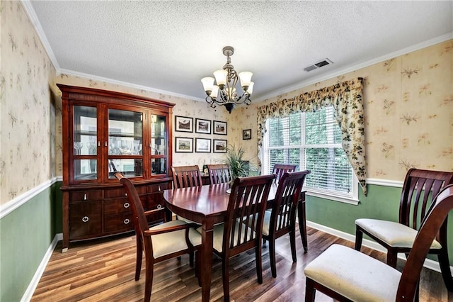 dining area with a chandelier, wood-type flooring, a textured ceiling, and crown molding