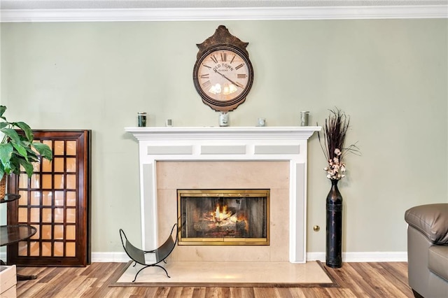 interior details featuring a premium fireplace, hardwood / wood-style flooring, and ornamental molding