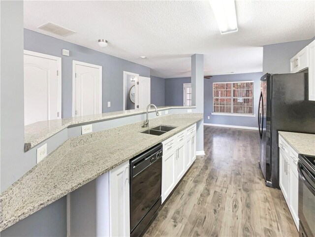 453 Inkberry Dr, Atlanta, GA 30349 - kitchen featuring black appliances, light stone countertops, light hardwood / wood-style floors, sink, and white cabinets