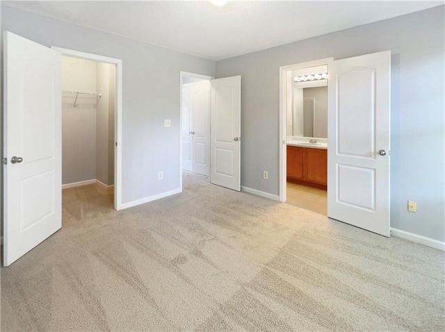 453 Inkberry Dr, Atlanta, GA 30349 - unfurnished bedroom with a closet, sink, a spacious closet, ensuite bathroom, and light colored carpet