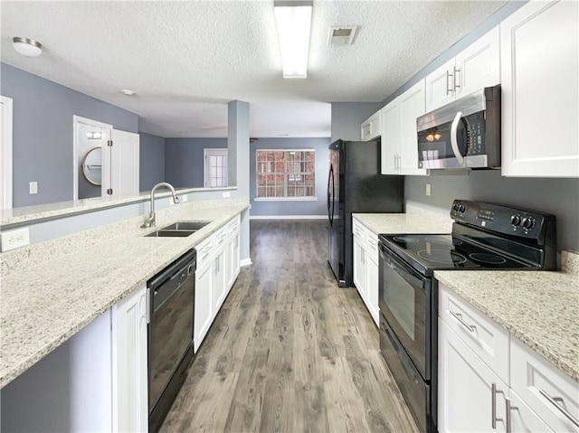 453 Inkberry Dr, Atlanta, GA 30349 - kitchen with hardwood / wood-style floors, sink, black appliances, white cabinets, and light stone countertops
