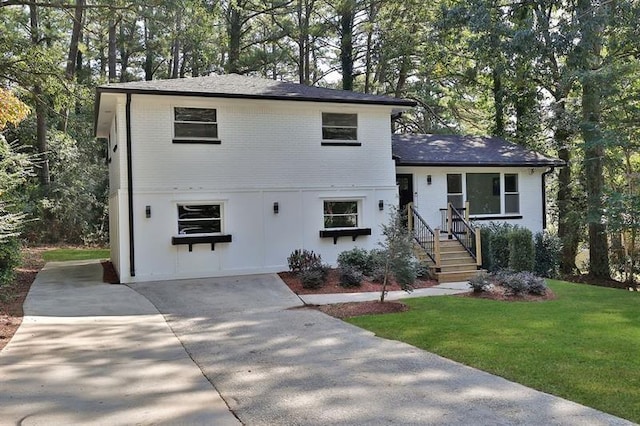 1770 Austin Dr, Decatur, GA 30032 - split level home featuring a front lawn, driveway, view of scattered trees, and brick siding