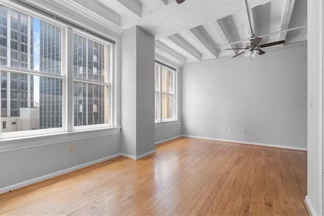 spare room featuring beamed ceiling, ceiling fan, and light hardwood / wood-style floors