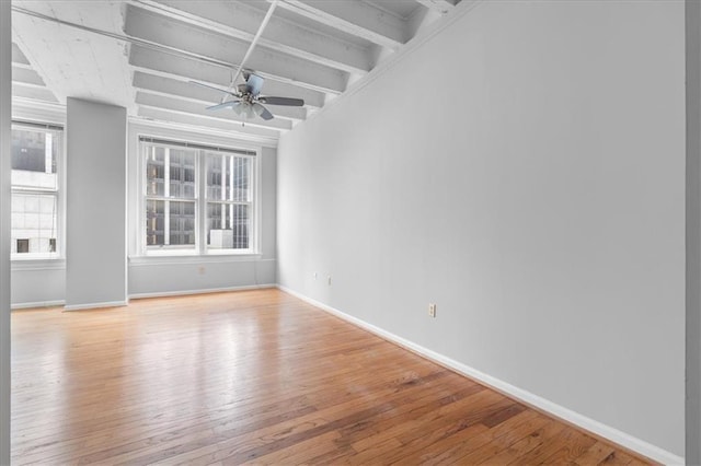 unfurnished room with beam ceiling, light hardwood / wood-style floors, and ceiling fan