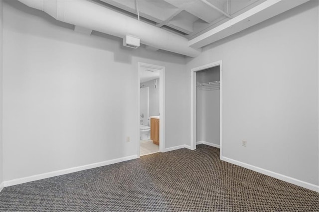 unfurnished bedroom featuring ensuite bathroom, carpet, and a closet