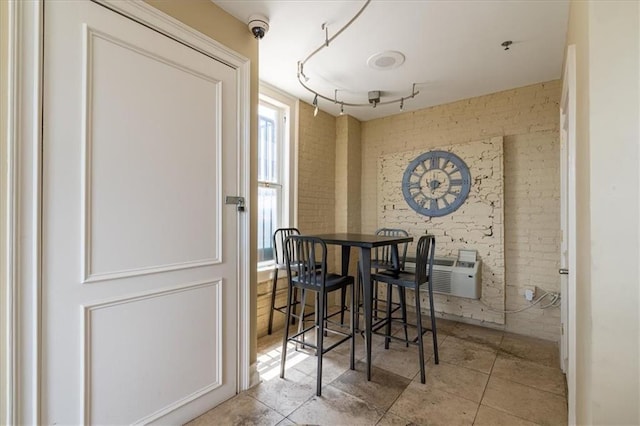 tiled dining space with brick wall and a wall mounted AC