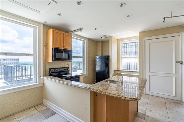 kitchen featuring sink, black appliances, and a healthy amount of sunlight