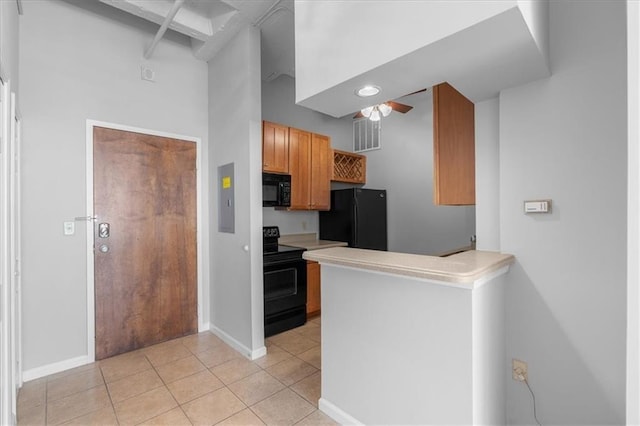 kitchen featuring light tile patterned floors, black appliances, kitchen peninsula, and ceiling fan