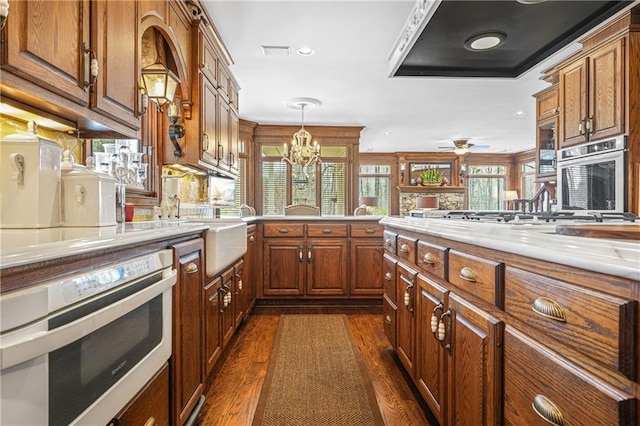 1500 Historic Vw, Stone Mountain, GA 30087 - kitchen featuring wall oven, brown cabinets, dark wood finished floors, a chandelier, and recessed lighting
