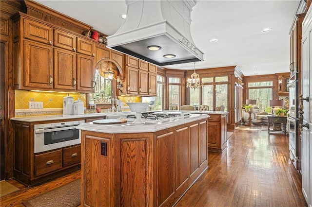 1500 Historic Vw, Stone Mountain, GA 30087 - kitchen with custom range hood, light countertops, gas cooktop, dark wood-type flooring, and a chandelier
