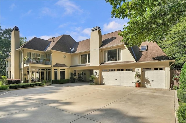 1500 Historic Vw, Stone Mountain, GA 30087 - view of front of house featuring a chimney, concrete driveway, a balcony, stucco siding, and an attached garage