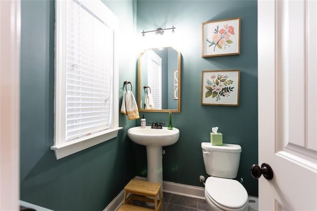 bathroom with baseboards, a sink, toilet, and tile patterned floors