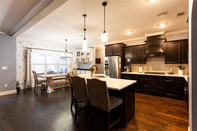 kitchen featuring dark wood finished floors, custom exhaust hood, light countertops, a sink, and high end refrigerator