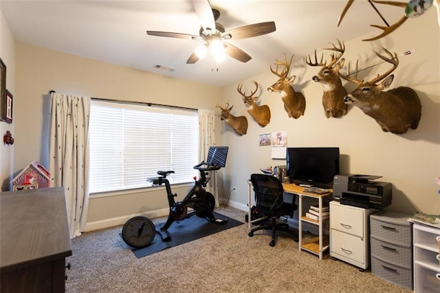 office space featuring baseboards, a ceiling fan, visible vents, and light colored carpet