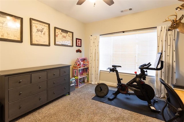 exercise area with a ceiling fan, light carpet, and visible vents