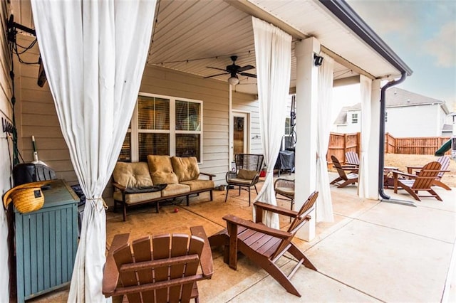 view of patio / terrace featuring ceiling fan, an outdoor living space with a fire pit, and fence