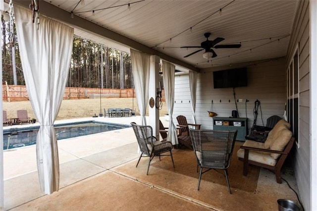 view of patio featuring fence, a fenced in pool, and a ceiling fan