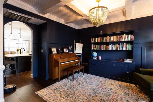 sitting room with dark wood-style floors, arched walkways, visible vents, coffered ceiling, and beamed ceiling