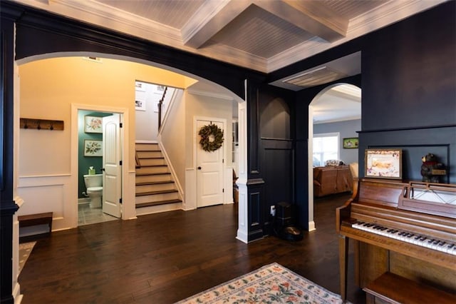 interior space with arched walkways, stairway, ornamental molding, wood finished floors, and beamed ceiling