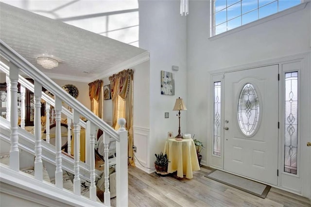 foyer with ornamental molding and light wood-type flooring