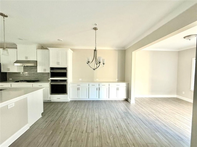 kitchen featuring hanging light fixtures, white cabinets, stainless steel double oven, and an inviting chandelier