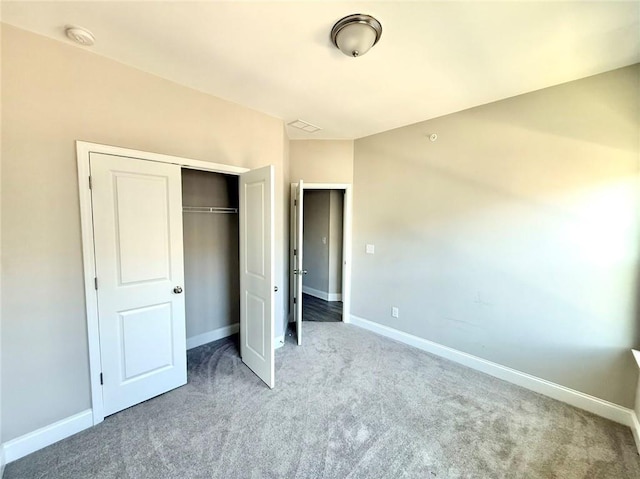 unfurnished bedroom featuring light carpet and a closet