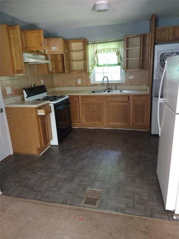 kitchen with visible vents, under cabinet range hood, freestanding refrigerator, gas stove, and a sink