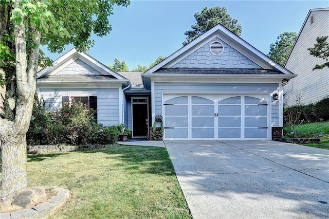 2220 Lily Valley Dr, Lawrenceville, GA 30045 - view of front of home featuring concrete driveway, a front yard, and a garage