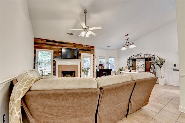 2220 Lily Valley Dr, Lawrenceville, GA 30045 - living room with a ceiling fan, a fireplace, light tile patterned floors, wood walls, and lofted ceiling