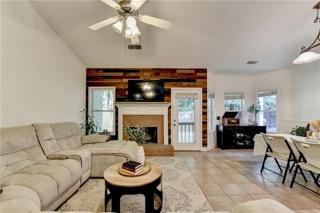 2220 Lily Valley Dr, Lawrenceville, GA 30045 - living area with light tile patterned floors, ceiling fan, a brick fireplace, wooden walls, and high vaulted ceiling