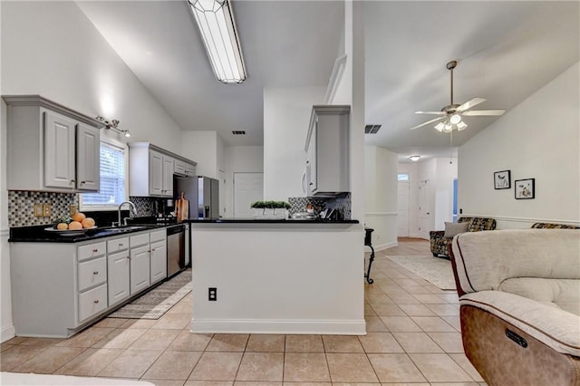 2220 Lily Valley Dr, Lawrenceville, GA 30045 - kitchen with open floor plan, appliances with stainless steel finishes, dark countertops, lofted ceiling, and light tile patterned floors