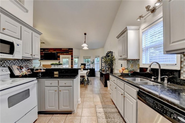 2220 Lily Valley Dr, Lawrenceville, GA 30045 - kitchen with white appliances, light tile patterned floors, a peninsula, healthy amount of natural light, and high vaulted ceiling