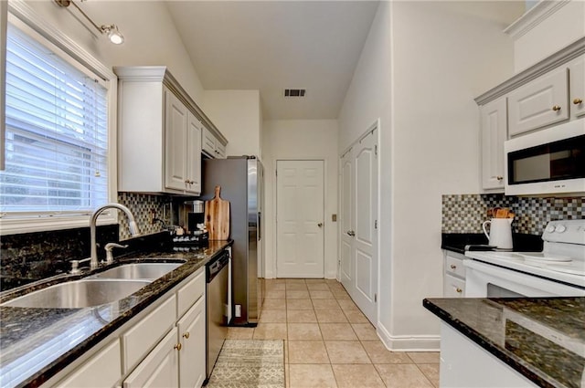 2220 Lily Valley Dr, Lawrenceville, GA 30045 - kitchen featuring white appliances, light tile patterned floors, backsplash, and dark stone countertops