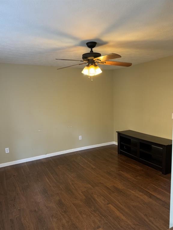 spare room featuring ceiling fan and dark hardwood / wood-style floors