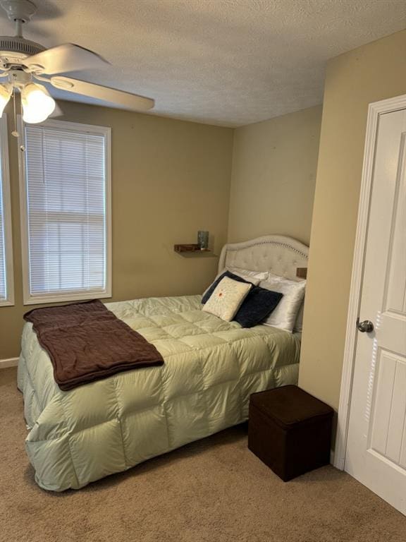 carpeted bedroom with a textured ceiling and ceiling fan