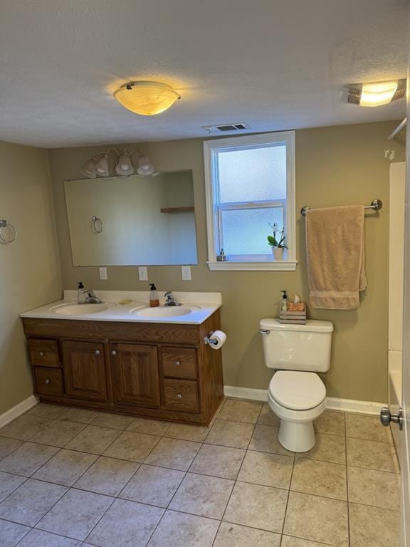 bathroom with toilet, tile patterned floors, and vanity