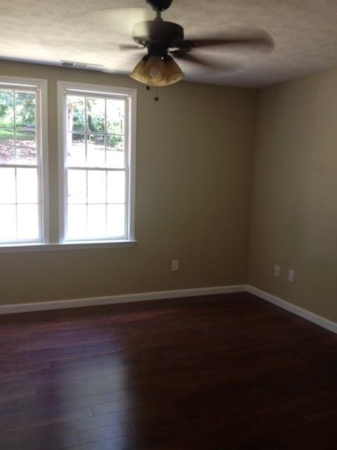 unfurnished room with dark wood-type flooring and ceiling fan