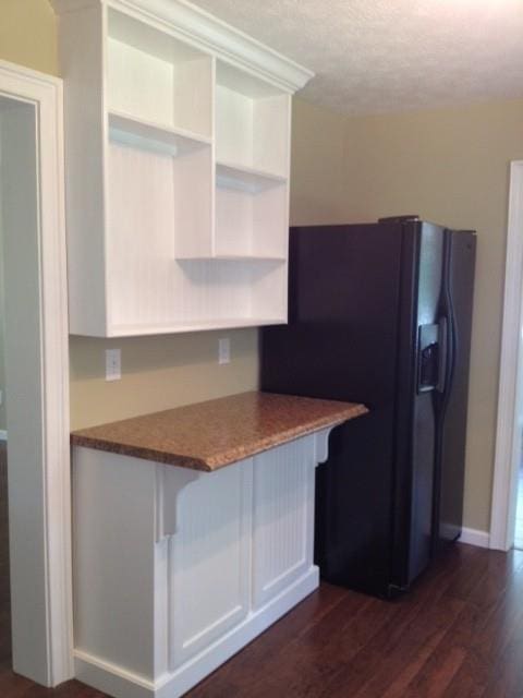 kitchen featuring black refrigerator with ice dispenser and dark hardwood / wood-style floors