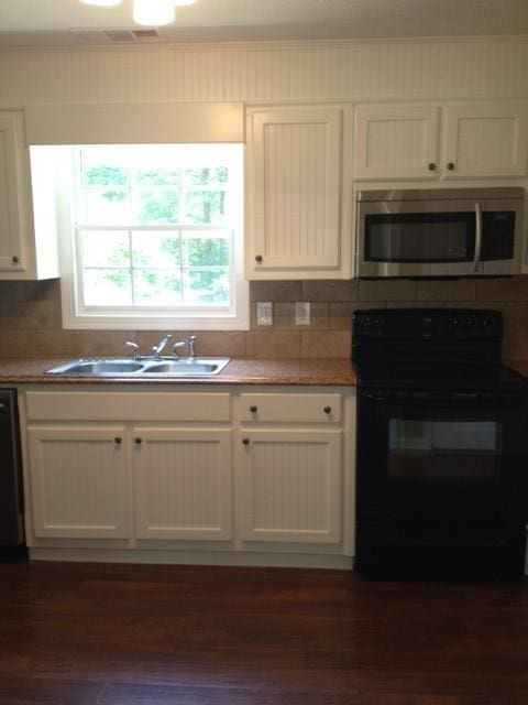 kitchen featuring sink, white cabinetry, black appliances, and dark hardwood / wood-style floors