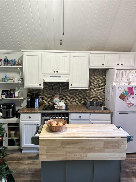 kitchen with white fridge, white cabinets, black gas range oven, and sink