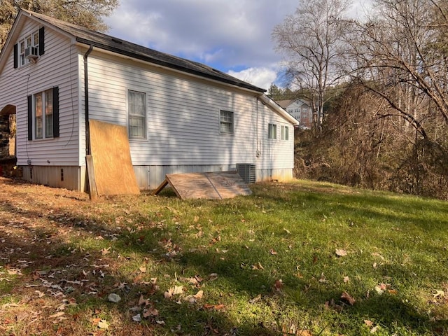 view of side of home featuring central AC and a lawn