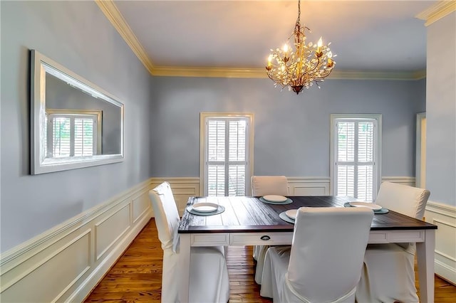 dining space with crown molding, dark wood-type flooring, and an inviting chandelier