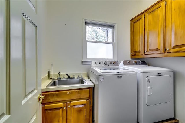 laundry area featuring cabinets, independent washer and dryer, and sink