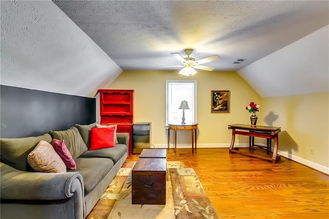 interior space with ceiling fan, hardwood / wood-style flooring, a textured ceiling, and vaulted ceiling