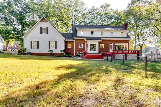 rear view of property with a deck and a yard