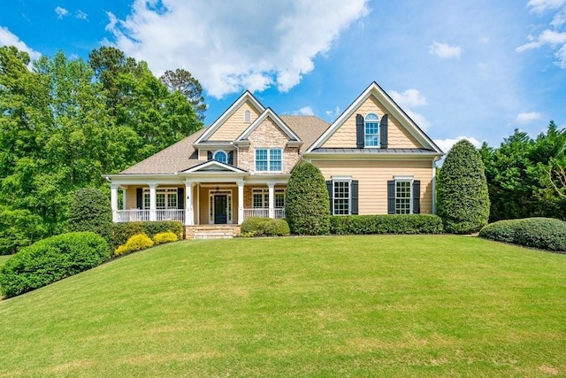 craftsman-style home featuring a front lawn and covered porch