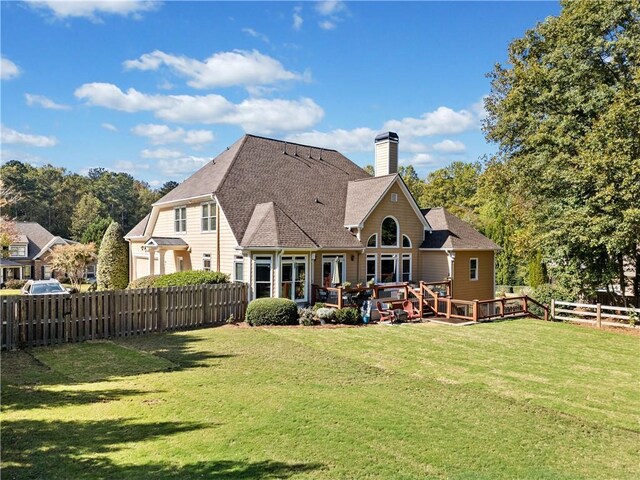 rear view of house with a wooden deck and a yard