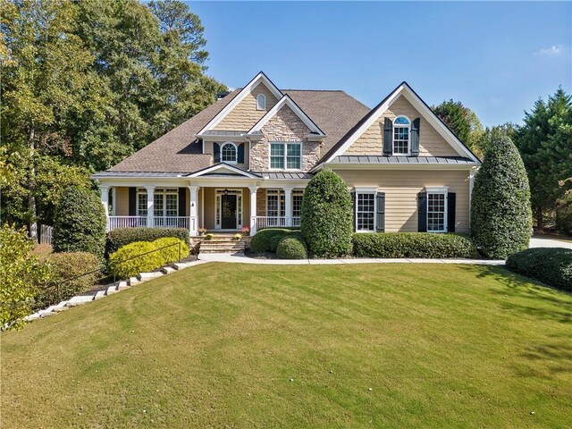 craftsman inspired home featuring a porch and a front lawn