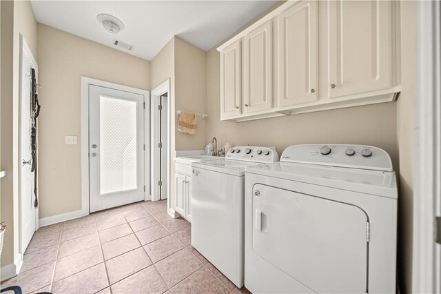 laundry area featuring cabinets, washing machine and dryer, light tile patterned floors, and sink